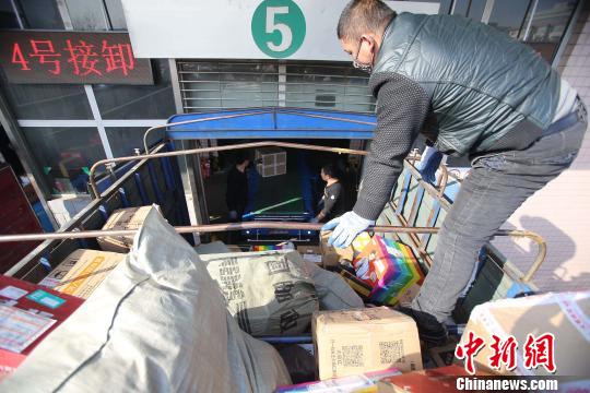 資料圖：工作人員正在給快遞包裹裝車(chē)。張?jiān)啤z
